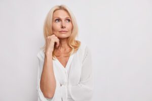 Mujer madura pensando sobre los síntomas de la menopausia
